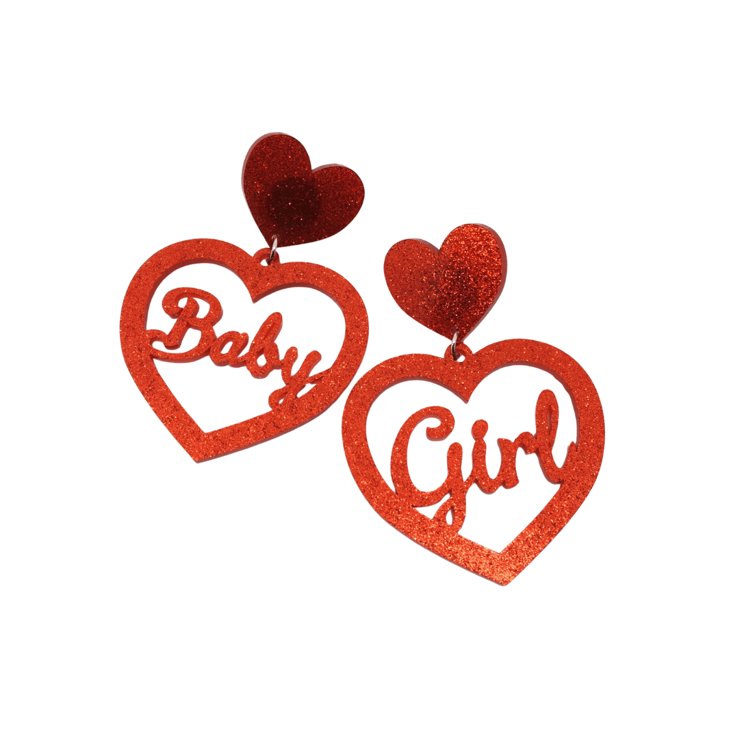 An Image of heart shaped dangle glitter heart earrings that say "Baby Girl"