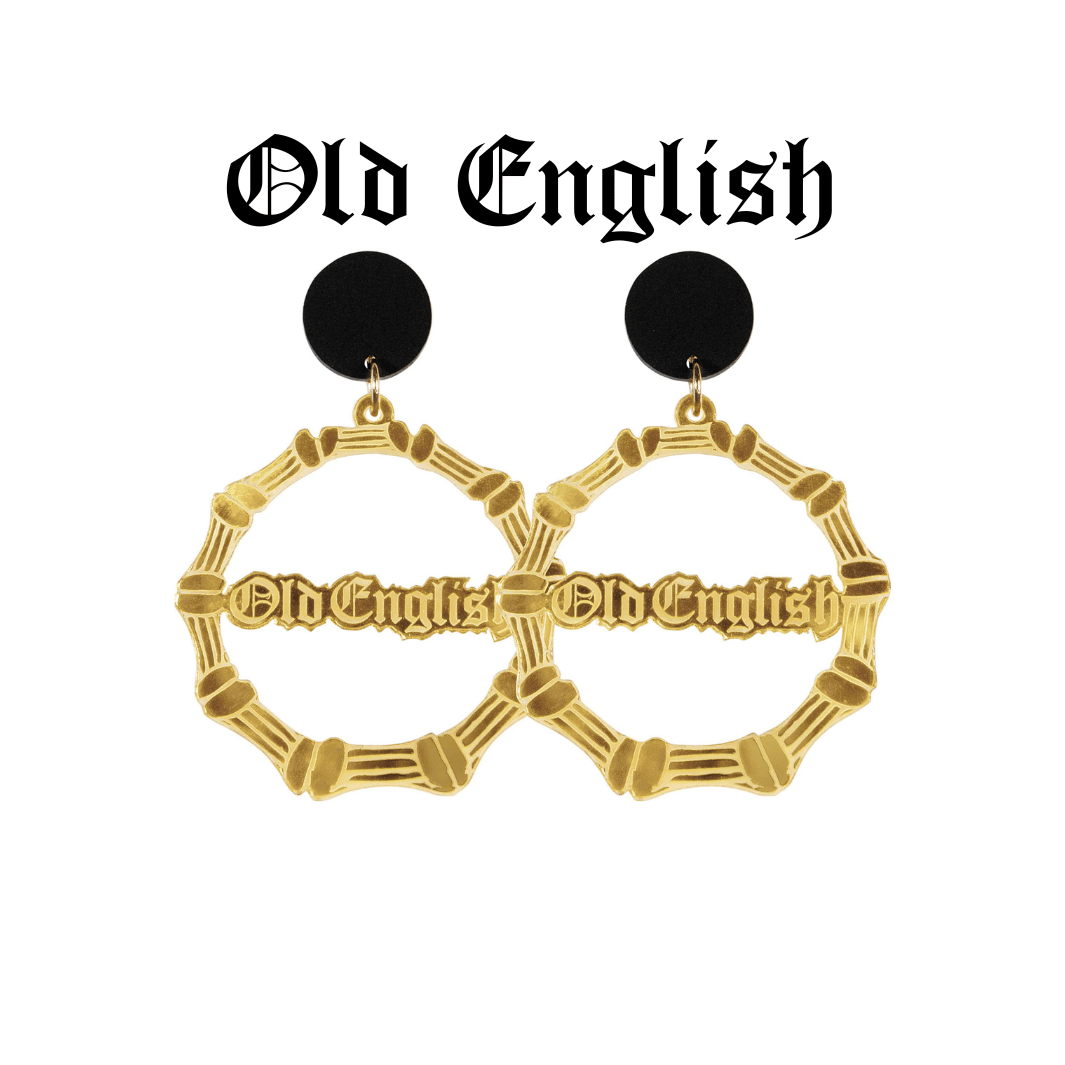 An image of Haus of Dizzy's large gold bamboo hoops with 'Old English' text in old english font, with matte black circle tops.