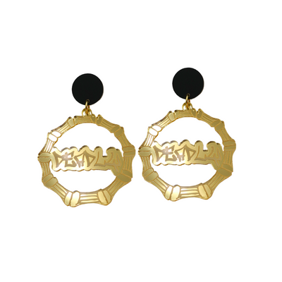 An image of Haus of Dizzy's small gold mirror bamboo hoops with 'Deadly' text in graffiti font, with matte black circle tops.