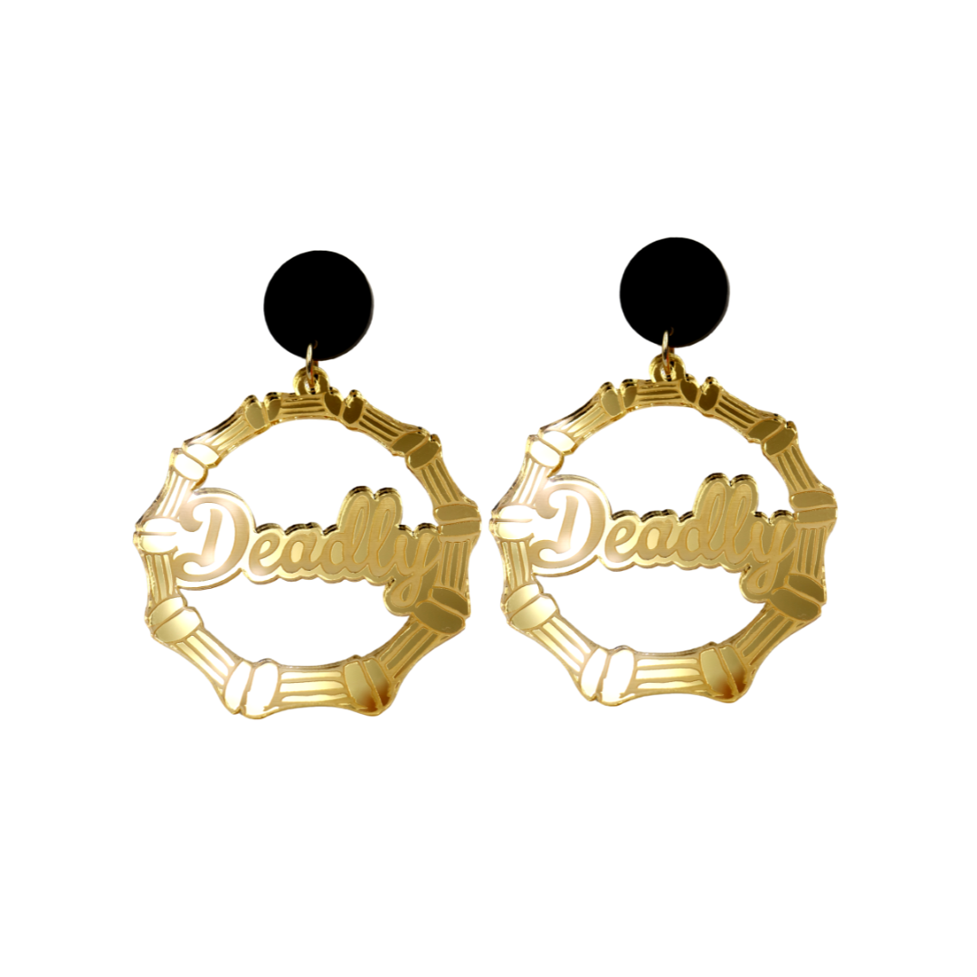 An image of Haus of Dizzy's small gold mirror bamboo hoops with 'Deadly' text in ollie cursive font, with matte black circle tops.