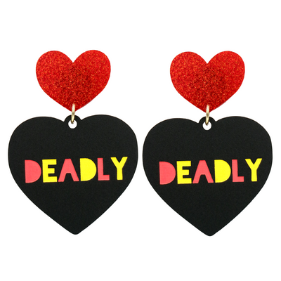 An image of Haus of Dizzy's large black acrylic dangle earrings with Deadly text in red and yellow, and a red glitter heart top.
