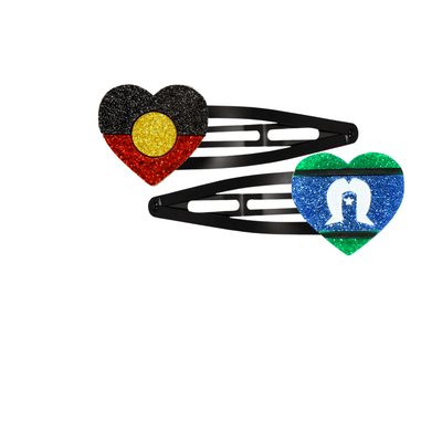 An Image of Haus of Dizzy's Heart Shaped Glitter Aboriginal Flag and Torres Strait Islander Hair Clips. Flags are on Black Hair Clips