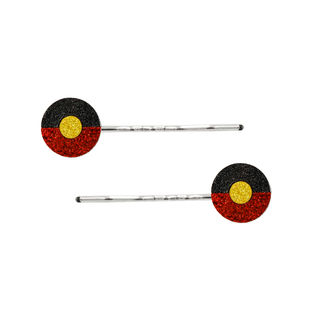 An Image of Haus of Dizzy's Circle Shaped Glitter Aboriginal Islander Flag Hair Pins. Flags are on Silver Pins