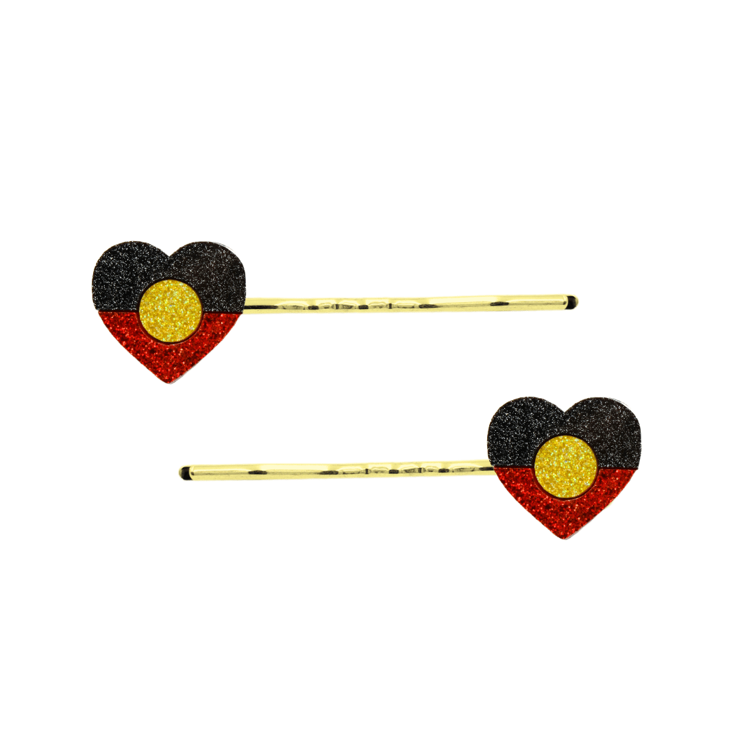 An Image of Haus of Dizzy's Heart Shaped Glitter Aboriginal Flag Hair Pins. Flags are on Gold Pins