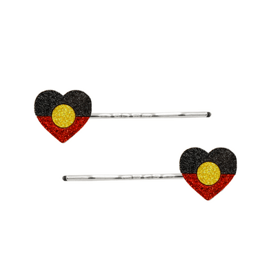 An Image of Haus of Dizzy's Heart Shaped Glitter AboriginalFlag Hair Pins. Flags are on Silver Pins