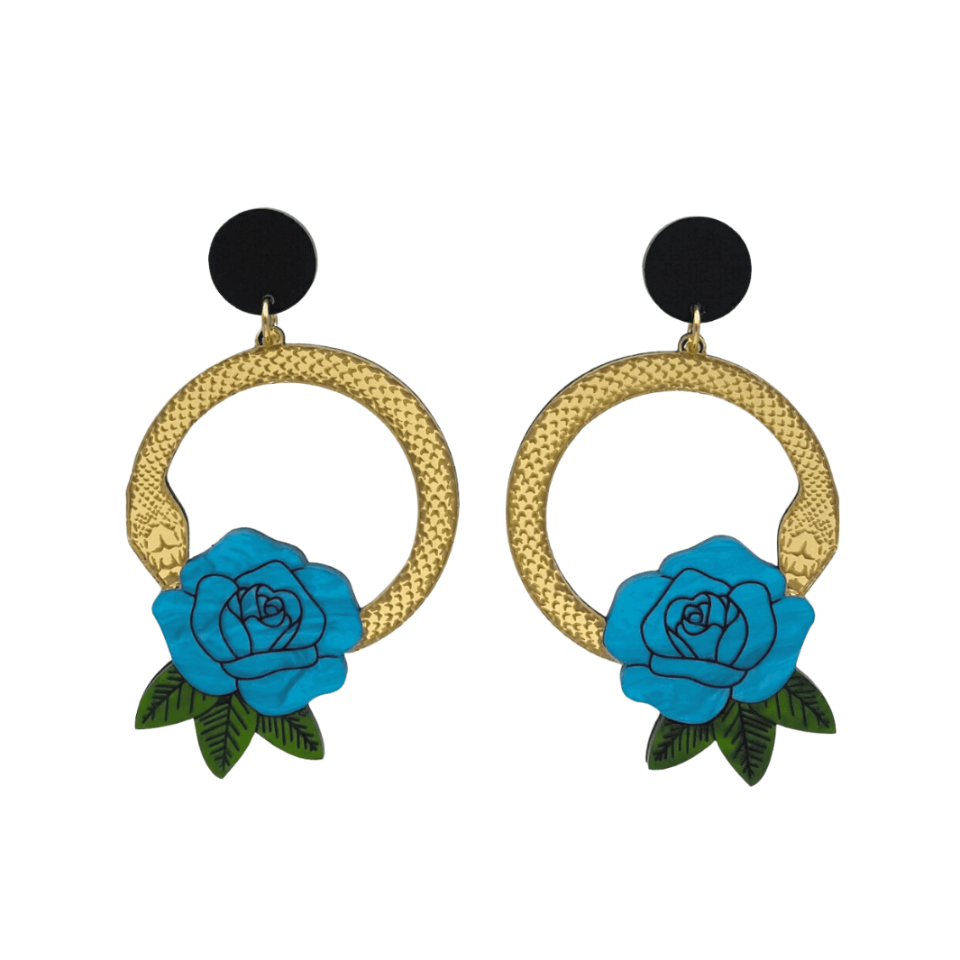An image of Haus of Dizzy's large Snake Rose hoop dangle earrings, featuring a gold snake in a circle with a cyan blue rose and matte black circle top.