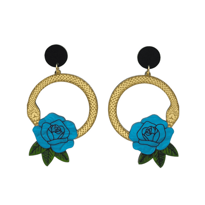An image of Haus of Dizzy's large Snake Rose hoop dangle earrings, featuring a gold snake in a circle with a cyan blue rose and matte black circle top.