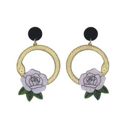 An image of Haus of Dizzy's large Snake Rose hoop dangle earrings, featuring a gold snake in a circle with a light pink rose and matte black circle top.