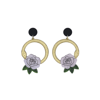 An image of Haus of Dizzy's small Snake Rose hoop dangle earrings, featuring a gold snake in a circle with a light pink rose and matte black circle top.