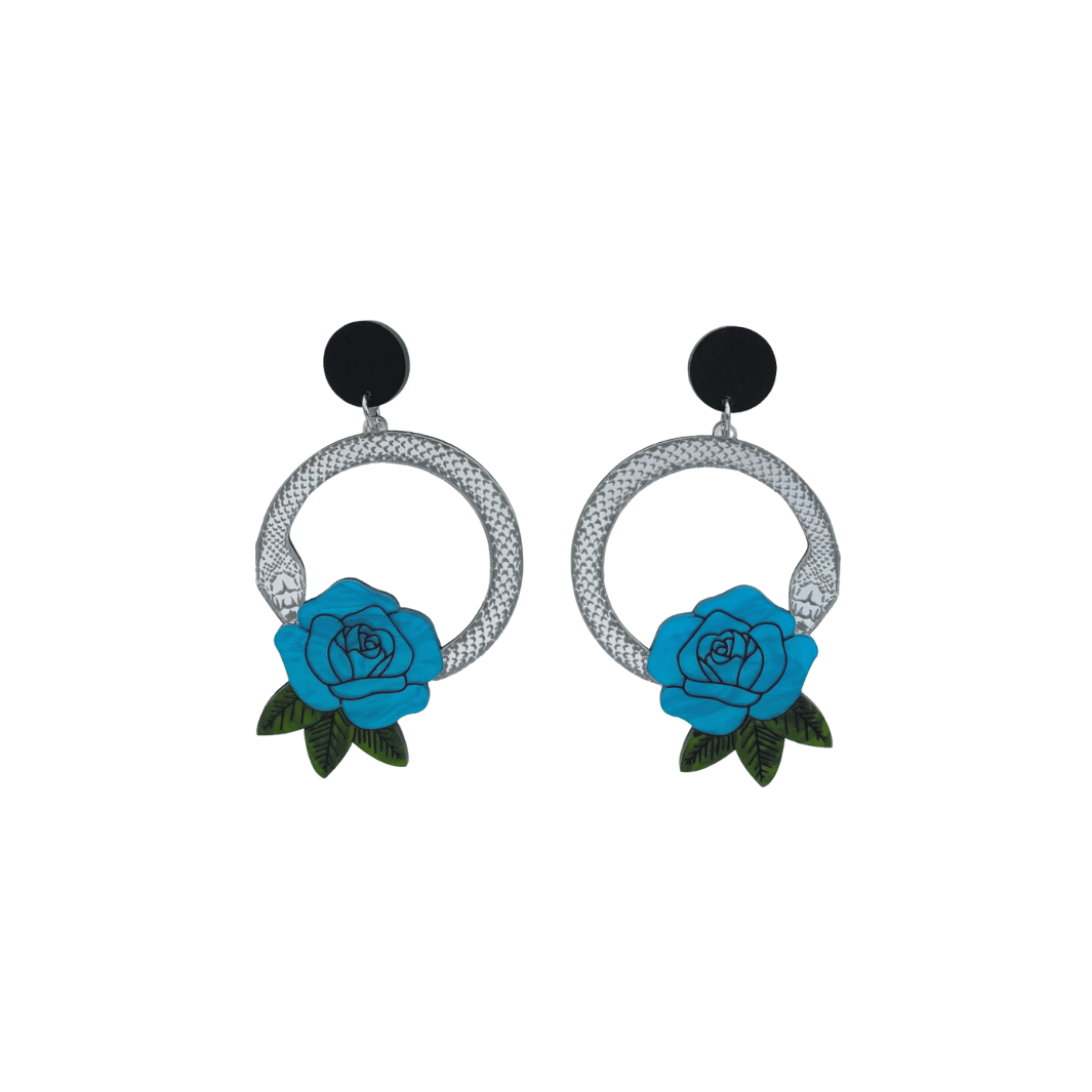 An image of Haus of Dizzy's small Snake Rose hoop dangle earrings, featuring a silver snake in a circle with a cyan blue rose and matte black circle top.
