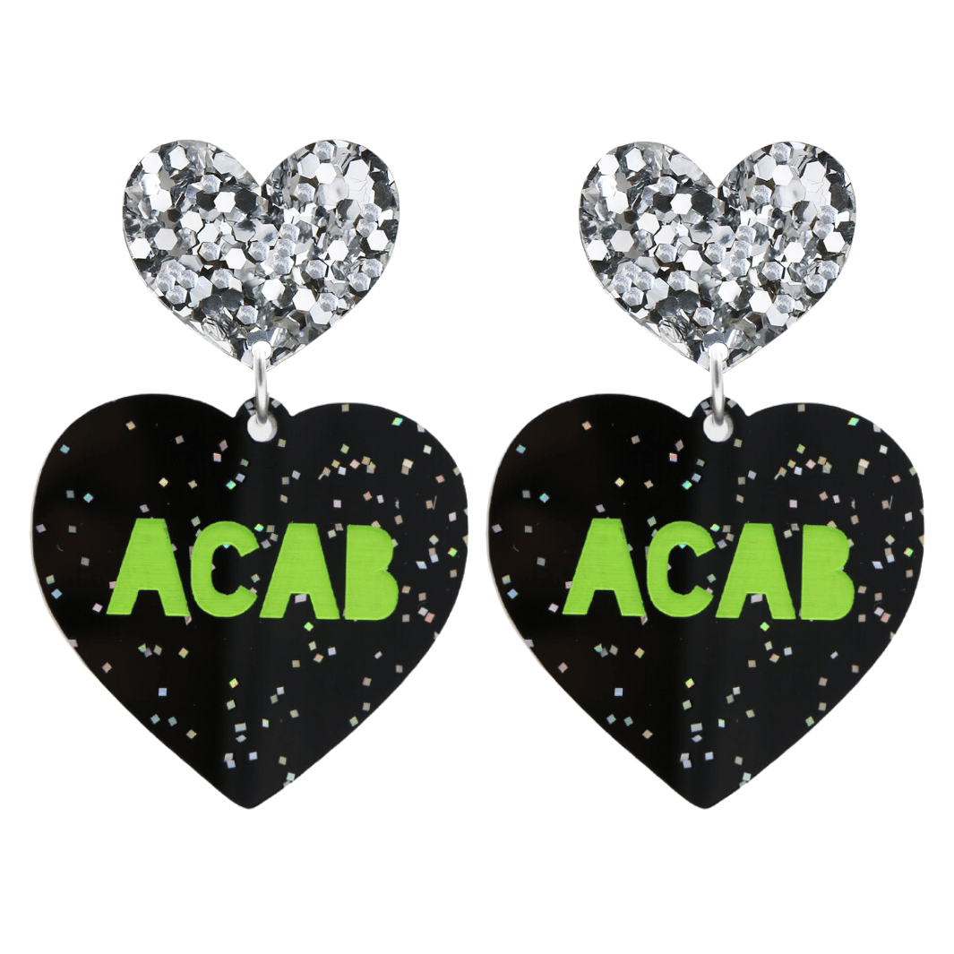 An image of Haus of Dizzy's Large ‘ACAB’ heart shaped dangle earrings, with Apple Green “ACAB” text on Black Glitter acrylic and a Silver Glitter heart top.