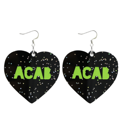 An image of Haus of Dizzy's Large ‘ACAB’ heart shaped dangle earrings, with Apple Green  “ACAB” text on Black Glitter acrylic and a Hook.
