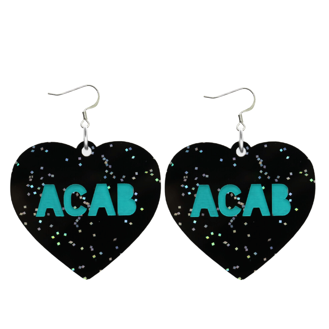 An image of Haus of Dizzy's Large ‘ACAB’ heart shaped dangle earrings, with Emerald  “ACAB” text on Black Glitter acrylic and a Hook.