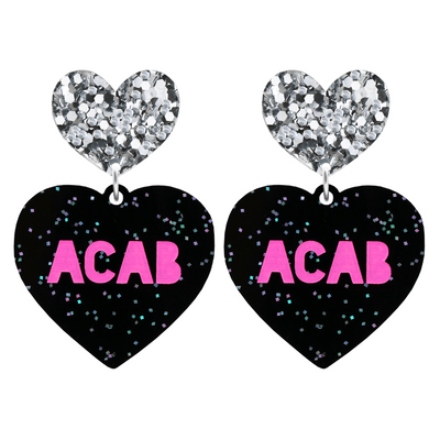 An image of Haus of Dizzy's Large ‘ACAB’ heart shaped dangle earrings, with Hot Pink  “ACAB” text on Black Glitter acrylic and a Silver Glitter heart top.