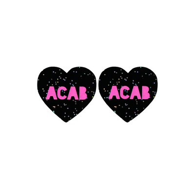 An image of Haus of Dizzy's Small  ‘ACAB’ heart shaped dangle earrings, with Hot Pink “ACAB” text on a Black Glitter acrylic stud heart.