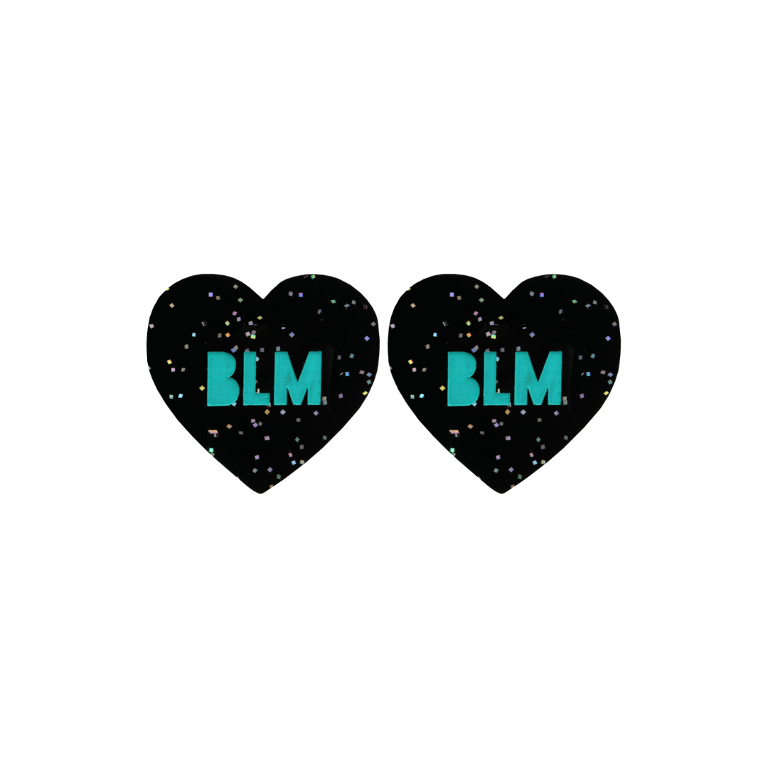 An image of Haus of Dizzy's Small ‘BLM’ heart shaped dangle earrings, with Emerald Green “BLM” text on a Black Glitter acrylic stud heart.