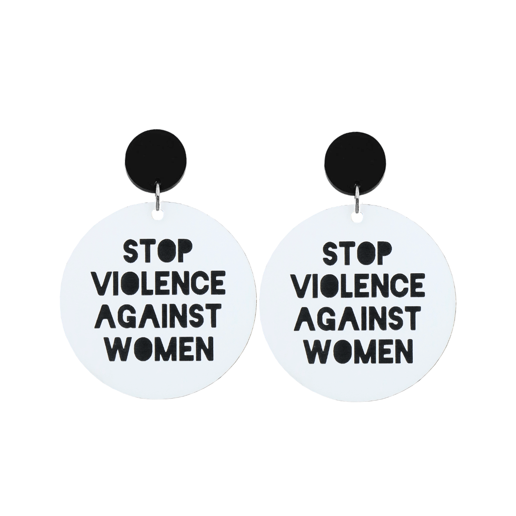 A picture of white acrylic dangle earrings with a black stud top that say "stop violence against women" in black text
