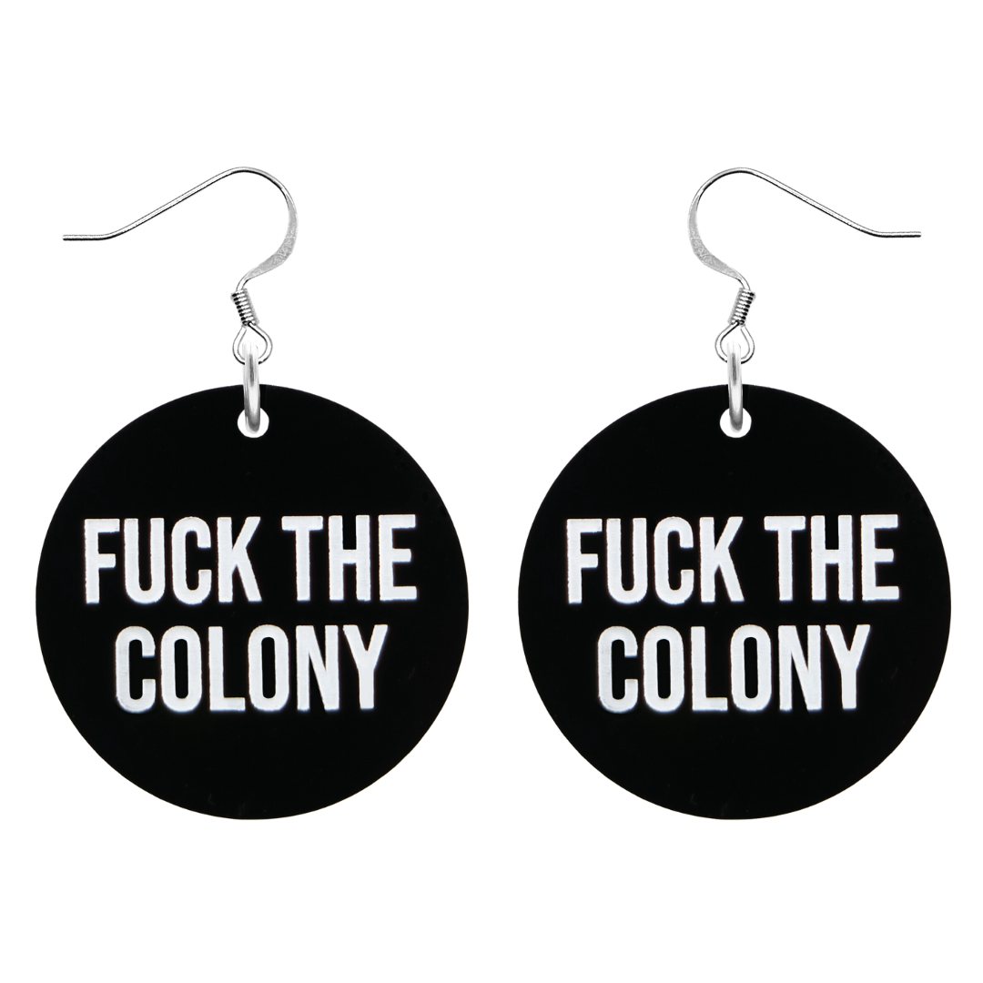 An image of Haus of Dizzy's ‘Fuck the Colony’ circle shaped dangle earrings, with white paint fill Fuck the Colony text on black acrylic and a silver hook top.