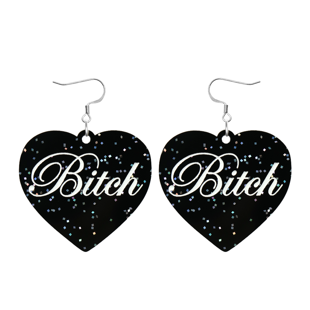 Black glitter Heart-shaped earrings with white text that says 'Bitch', and silver hooks (no heart tops) on a white background