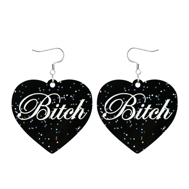 Black glitter Heart-shaped earrings with white text that says 'Bitch', and silver hooks (no heart tops) on a white background