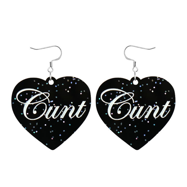 Black glitter Heart-shaped earrings with white text that says 'Cunt', and silver hooks (no heart tops) on a white background