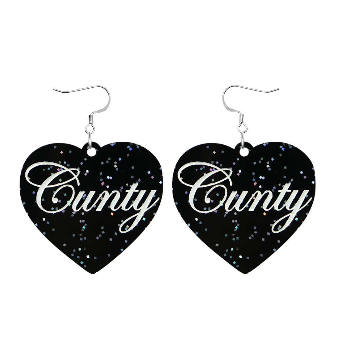 Black glitter Heart-shaped earrings with white text that says 'Cunty', and silver hooks (no heart tops) on a white background