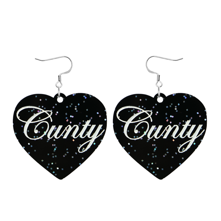 Black glitter Heart-shaped earrings with white text that says 'Cunty', and silver hooks (no heart tops) on a white background