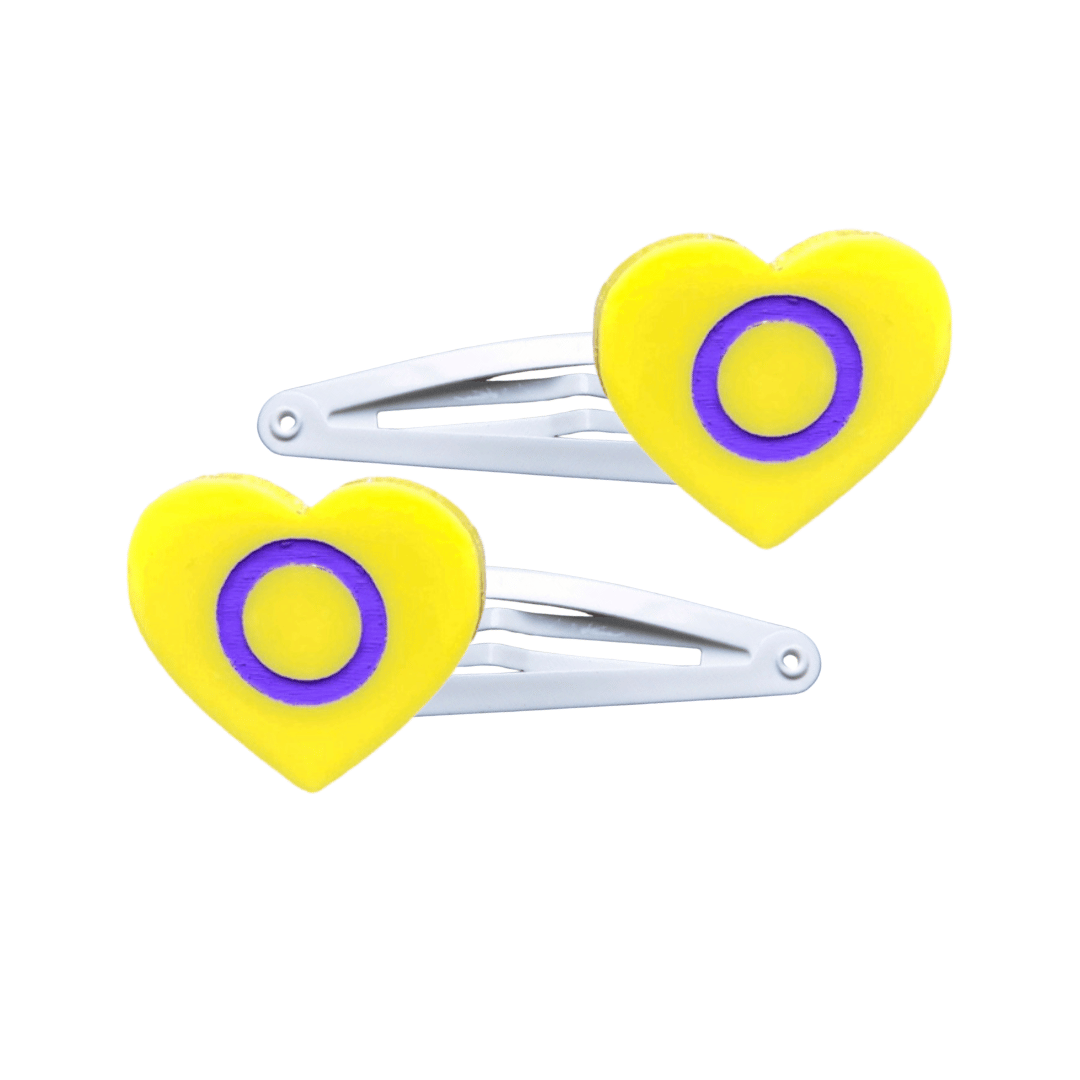Two heart-shaped intersex pride flag hair clips on a white background