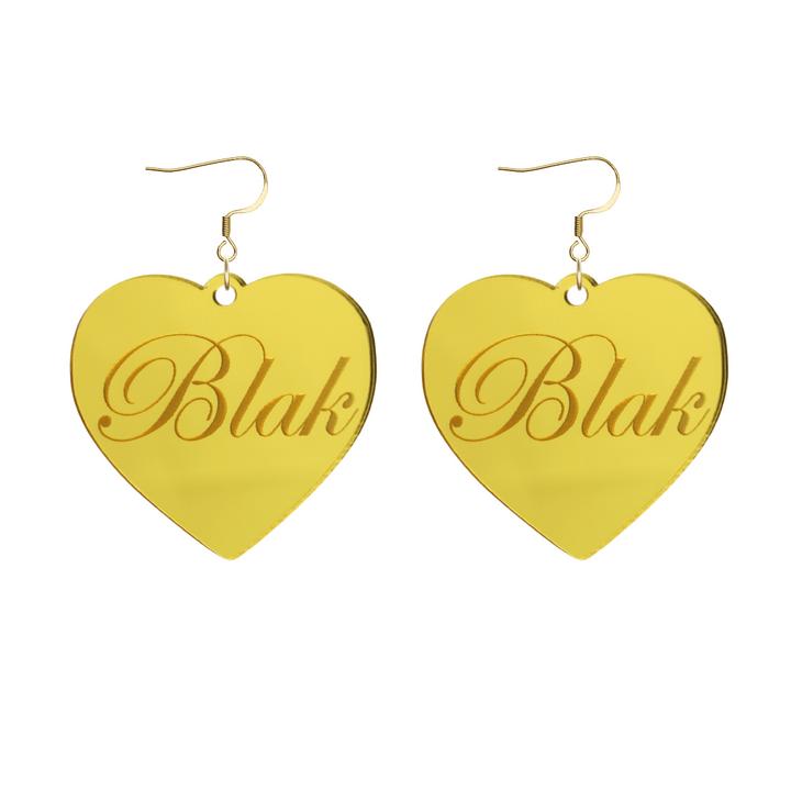 Heart-shaped gold mirror acrylic earrings with 'Blak' engraving on a white background