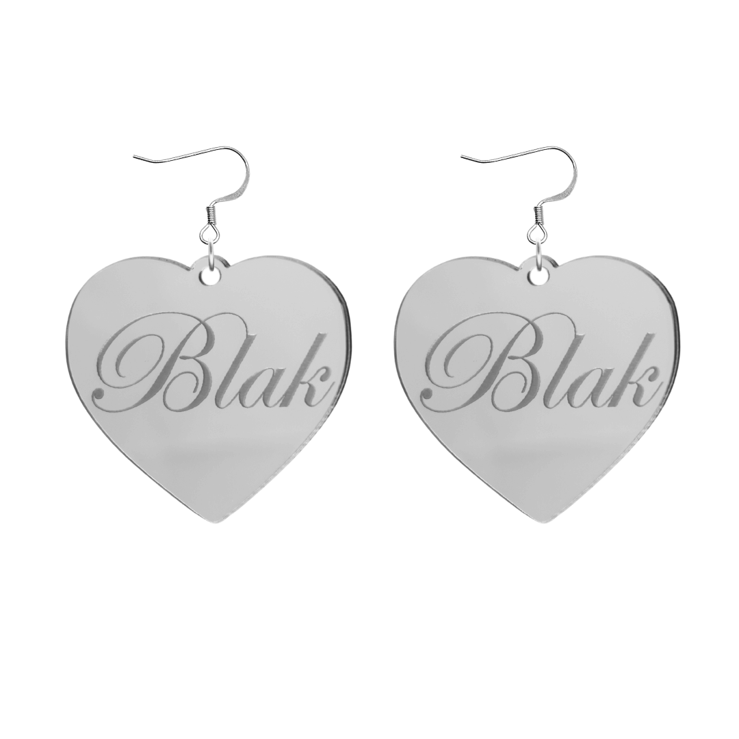 Heart-shaped silver mirror acrylic earrings with 'Blak' engraving on a white background
