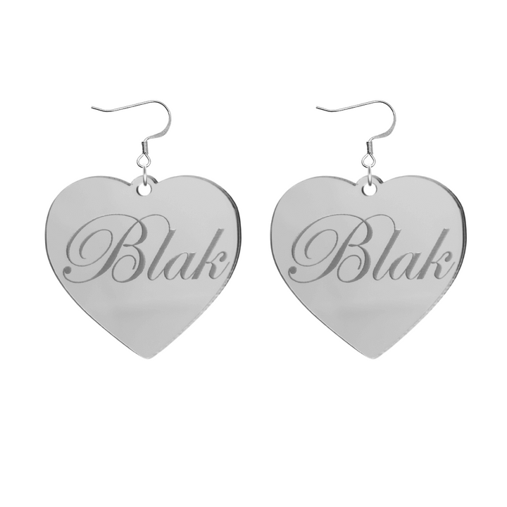 Heart-shaped silver mirror acrylic earrings with 'Blak' engraving on a white background