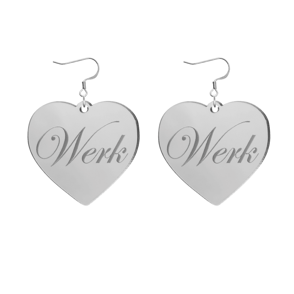Heart-shaped silver mirror acrylic earrings with 'Werk' engraving on a white background