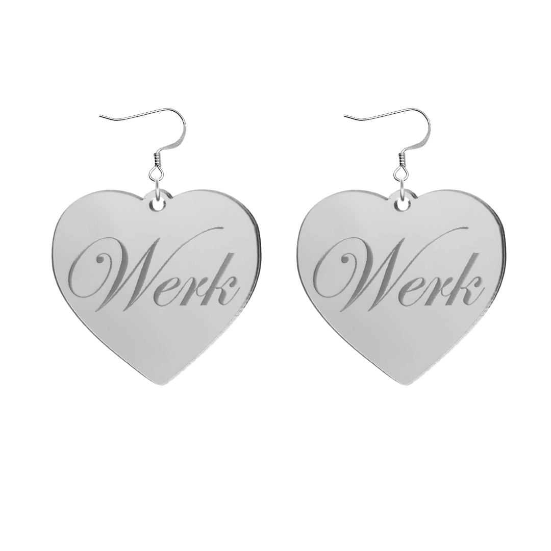 Heart-shaped silver mirror acrylic earrings with 'Werk' engraving on a white background