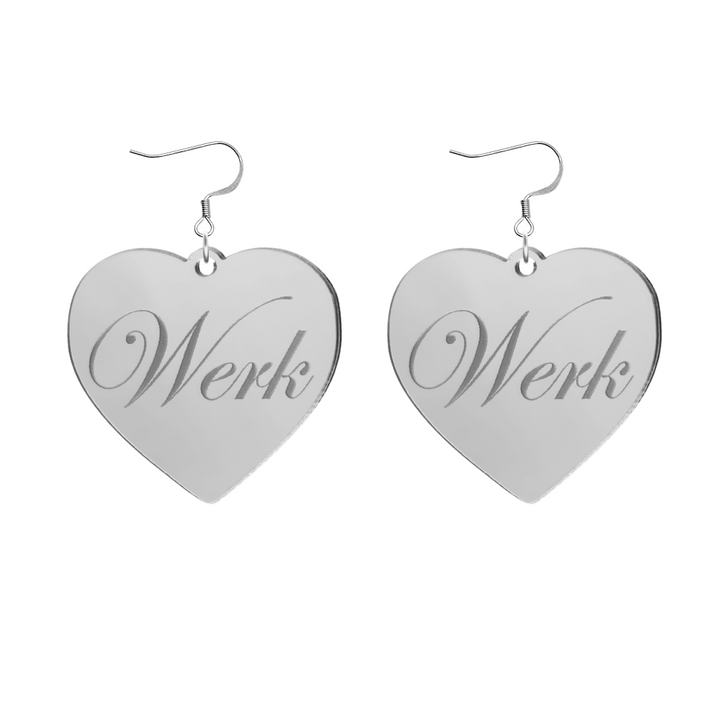Heart-shaped silver mirror acrylic earrings with 'Werk' engraving on a white background