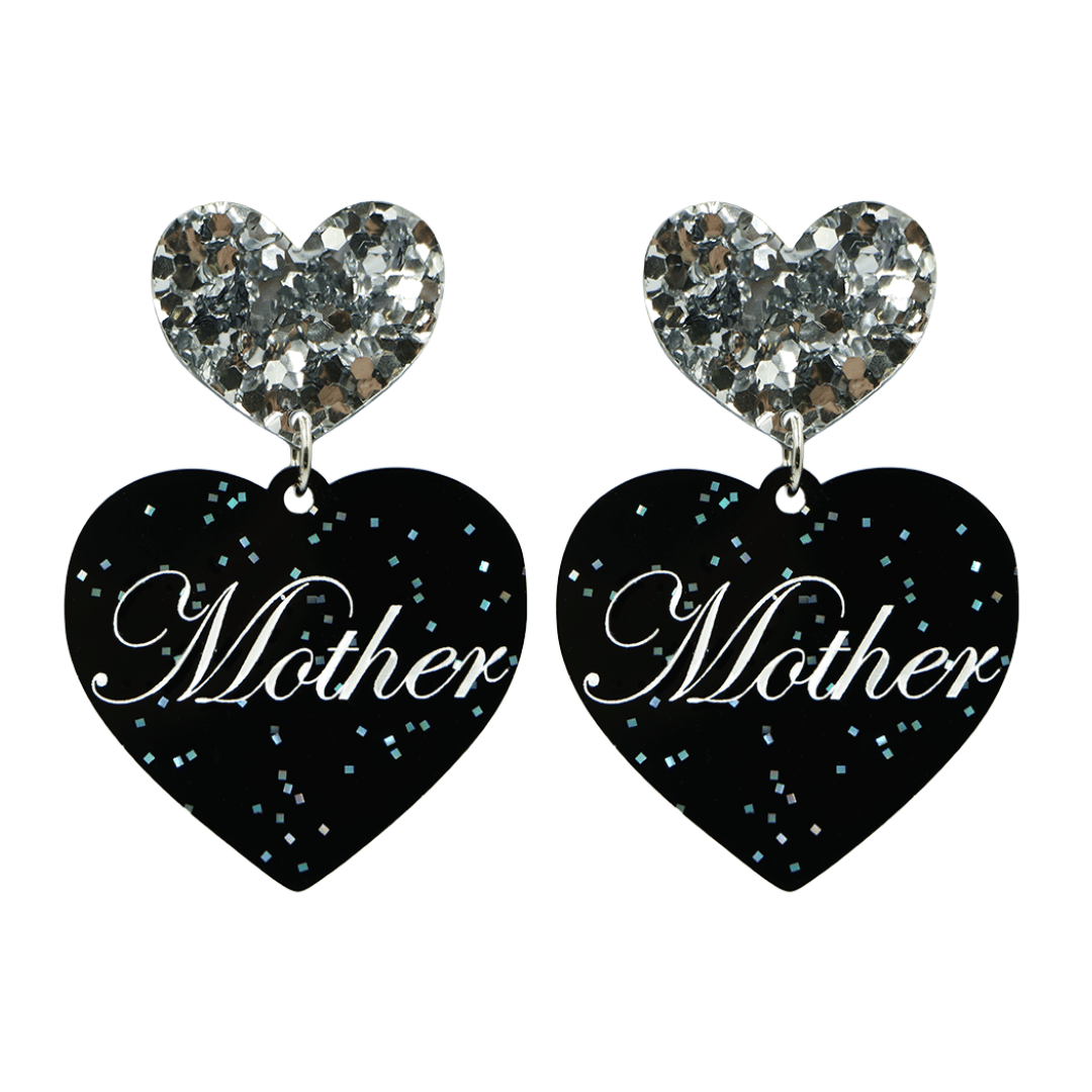 Black glitter Heart-shaped earrings with white text that says 'Mother', and silver glitter heart tops on a white background