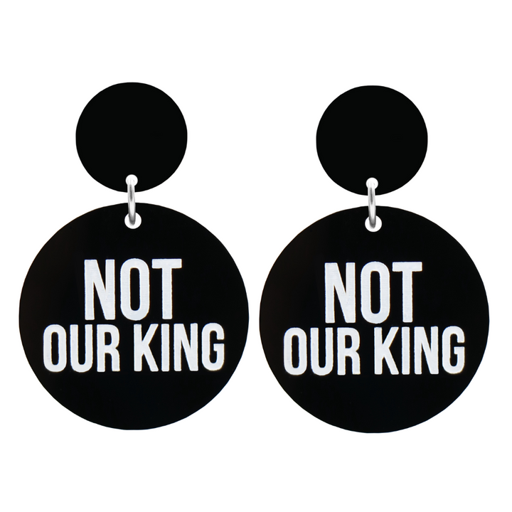 An image of Haus of Dizzy's Not our King circle-shaped dangle earrings, with Not our King text on gloss black acrylic and a gloss black circle top.