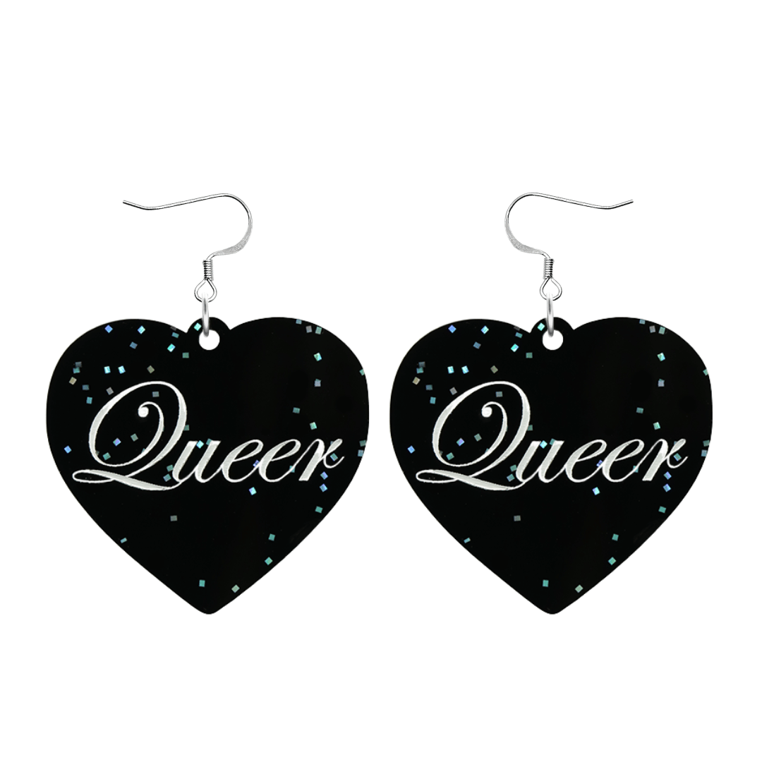 Black glitter Heart-shaped earrings with white text that says 'Queer', and silver hooks (no heart tops) on a white background