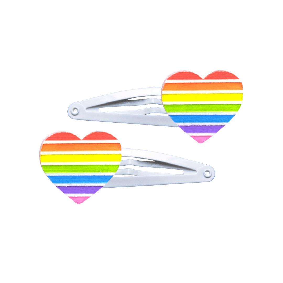 Two heart-shaped rainbow pride flag hair clips on a white background