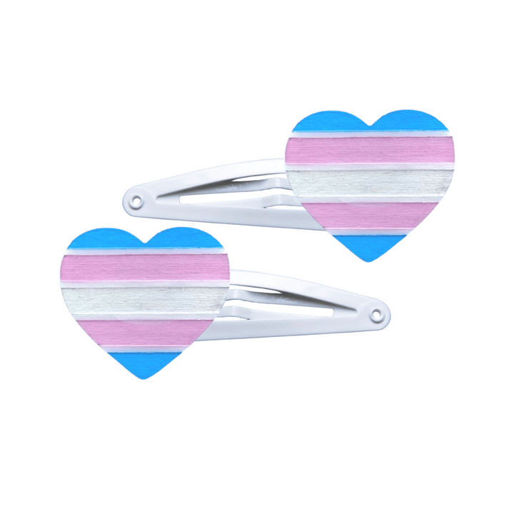 Two heart-shaped transgender pride flag hair clips on a white background