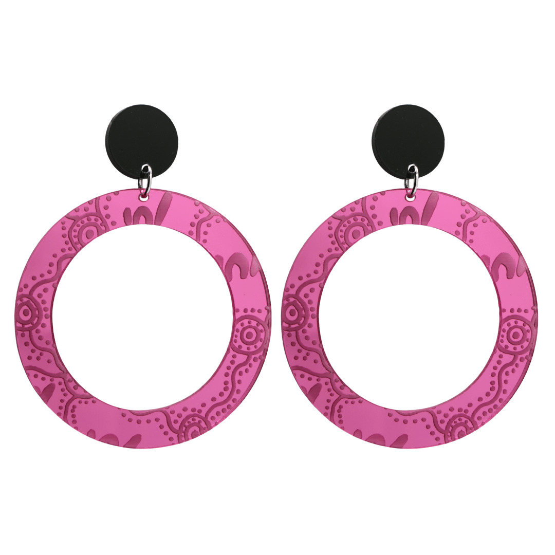 Pair of large, pink mirror, acrylic hoop earrings with Aboriginal artwork pattern with black circular earring top. Earrings are on a white background