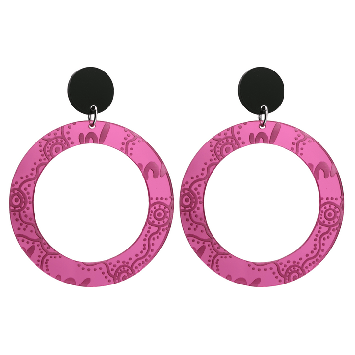 Pair of large, pink mirror, acrylic hoop earrings with Aboriginal artwork pattern with black circular earring top. Earrings are on a white background