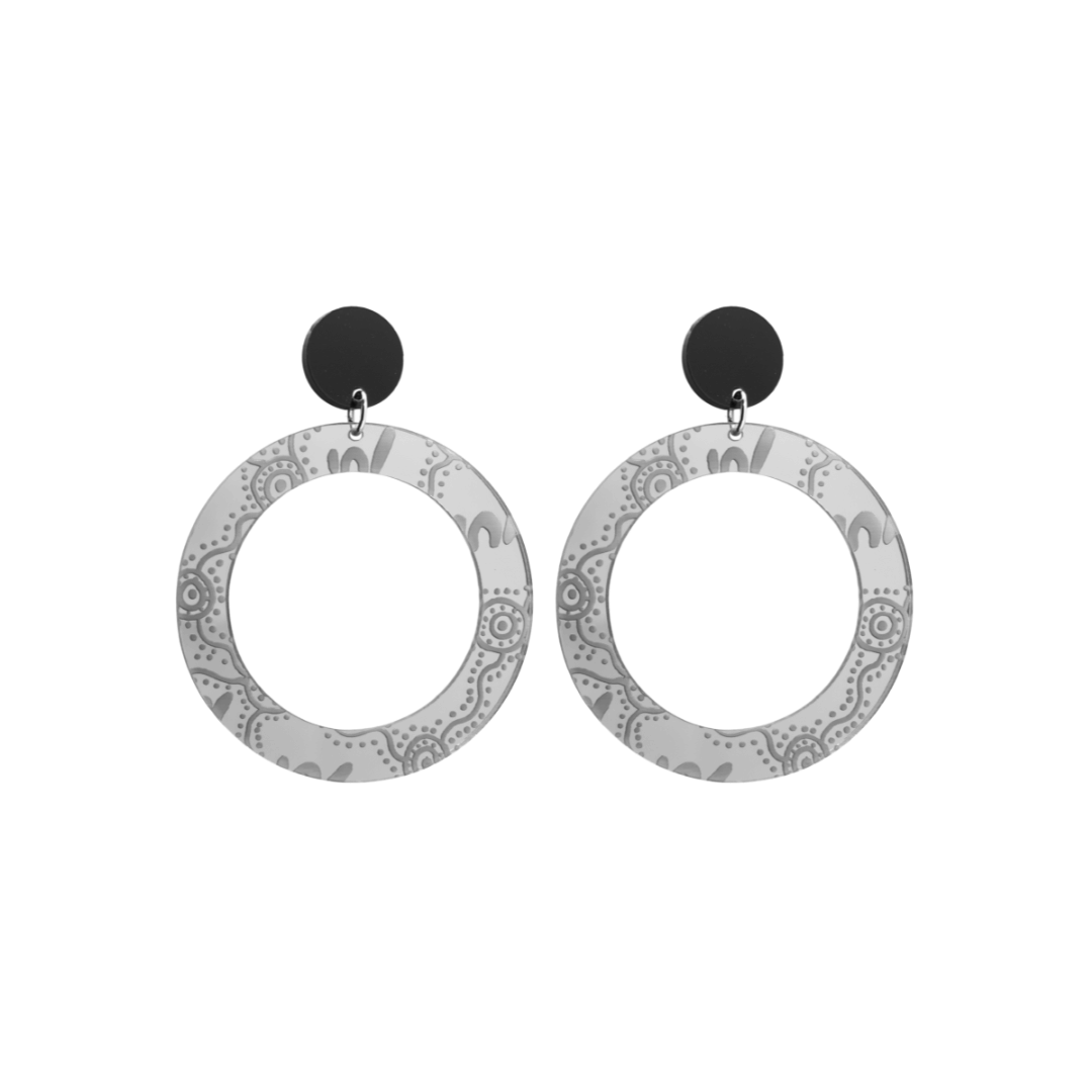 Pair of small, silver mirror, acrylic hoop earrings with Aboriginal artwork pattern with black circular earring top. Earrings are on a white background