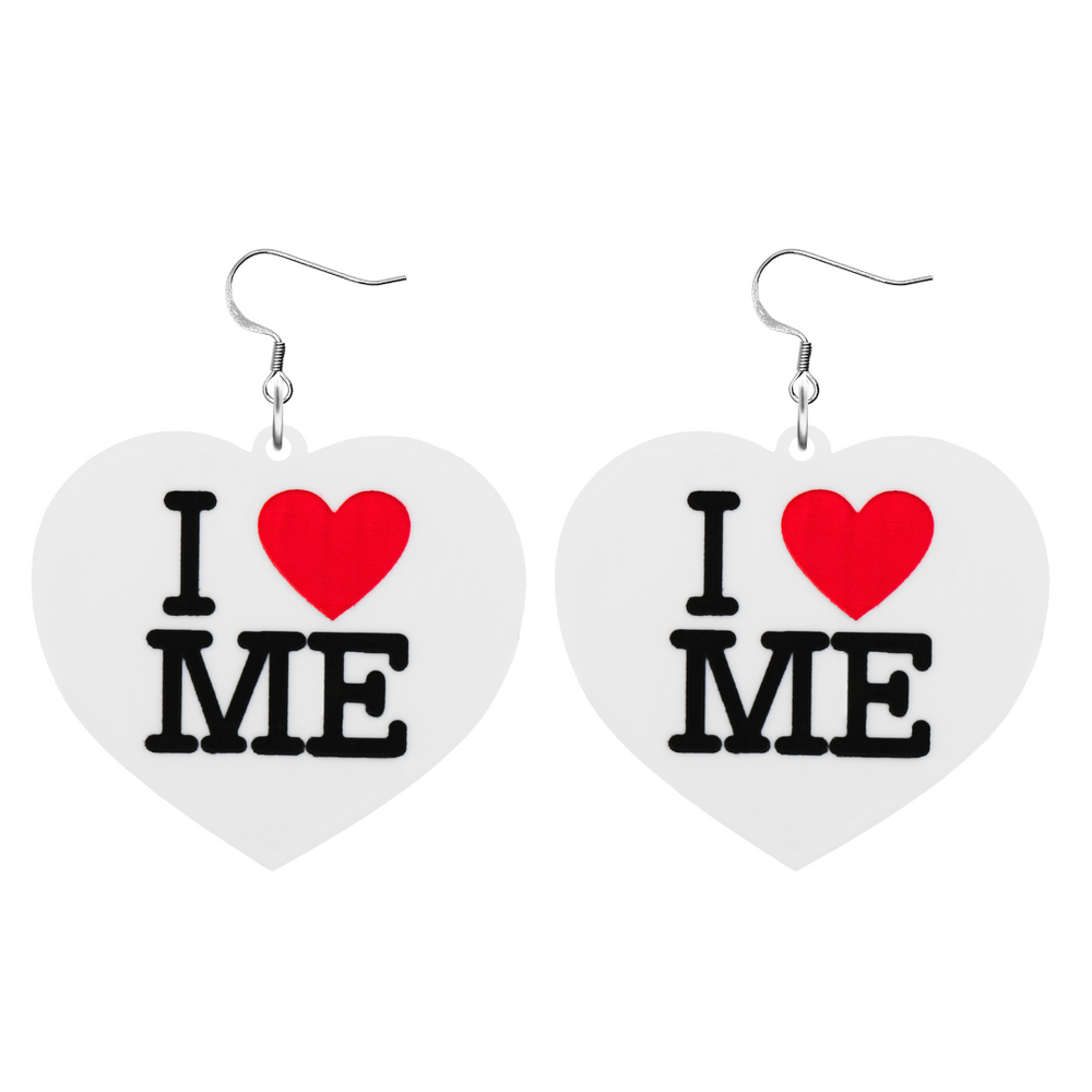 An image of Haus of Dizzy's large I Love Me heart shaped dangle earrings, with I Heart Me text on white acrylic and a hook top.