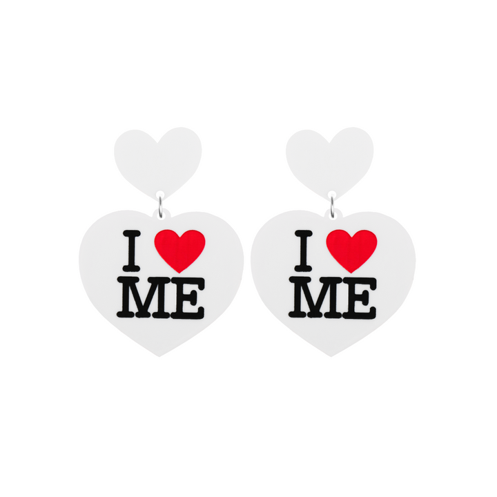 An image of Haus of Dizzy's small I Love Me heart shaped dangle earrings, with I Heart Me text on white acrylic and a white heart top.