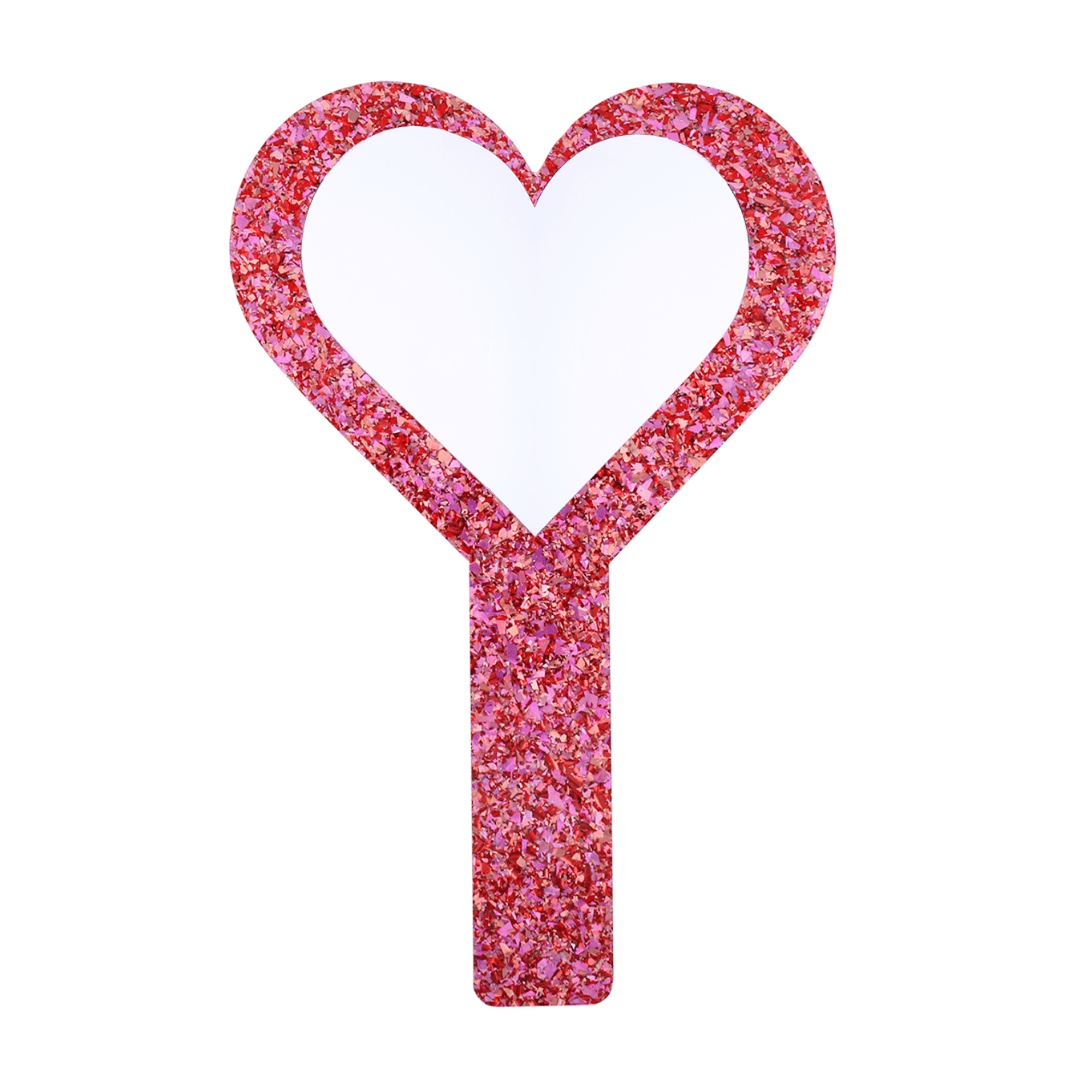 Pink glittery hand held heart mirror with heart-shaped mirror piece on a white background
