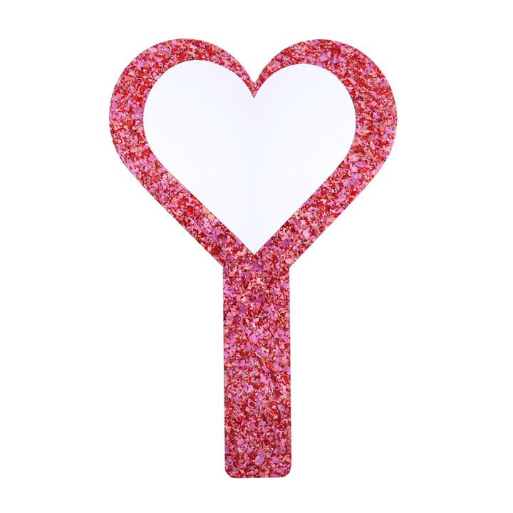 Pink glittery hand held heart mirror with heart-shaped mirror piece on a white background