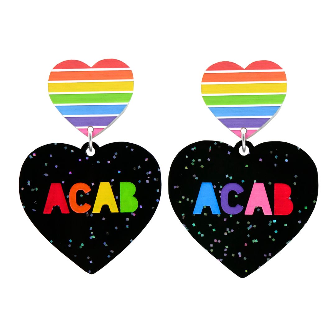 An image of Haus of Dizzy's large 'F U ACAB' heart-shaped dangle earrings, with “ACAB” rainbow text on black glitter acrylic and a pride rainbow heart top.