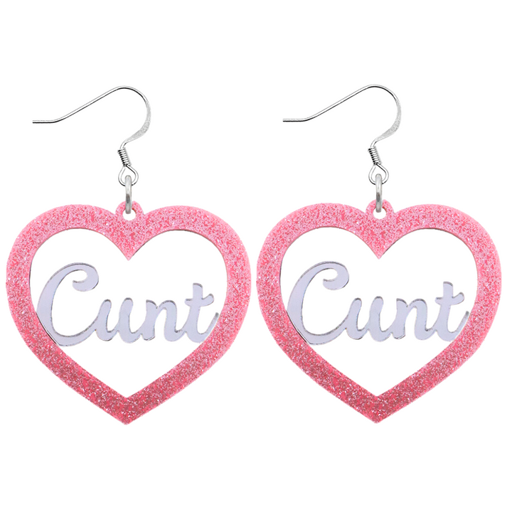 An image of Haus of Dizzy's Large ‘Cunt' heart shaped dangle earrings, with mirror "Cunt" text on a Baby Pink Glitter acrylic on a hook.