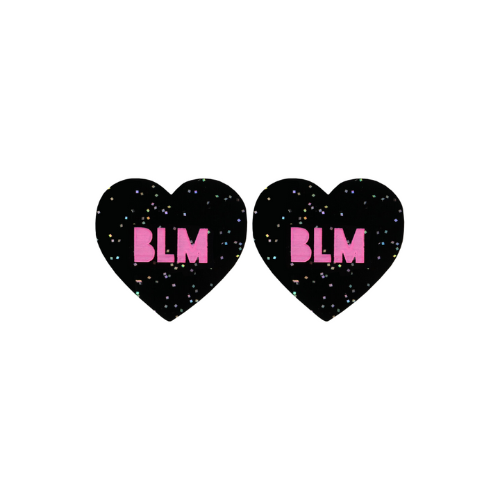 An image of Haus of Dizzy's Small ‘BLM’ heart shaped dangle earrings, with Hot Pink “BLM” text on a Black Glitter acrylic stud heart.