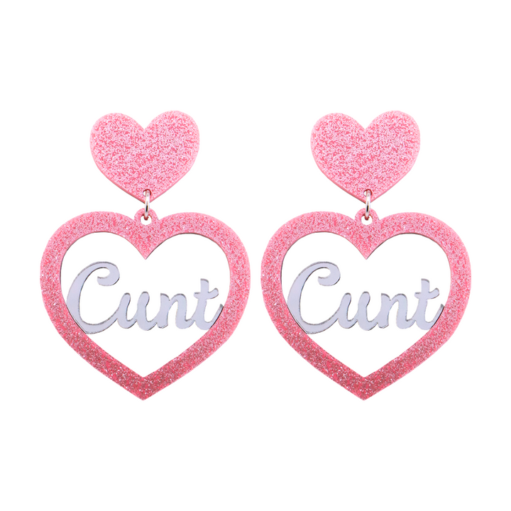 An image of Haus of Dizzy's Small ‘Cunt' heart shaped dangle earrings, with mirror "Cunt" text on a Baby Pink Glitter acrylic stud heart.